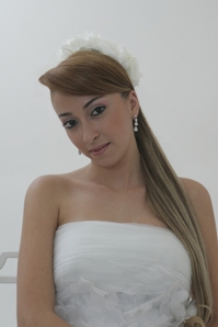 Noiva com rabo de cavalo liso e arrnajo de flores com maquiagem natural