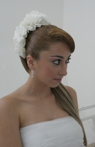 Noiva com rabo de cavalo liso e arrnajo de flores com maquiagem natural